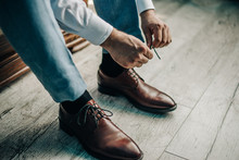 Young Guy Tying Shoelace On Leather Shoes