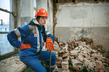 Destroying gender stereotypes. Woman wearing helmet using different male work tools. Gender equality. Girl working at flat remodeling. Building, repair and renovation. woman in the male profession