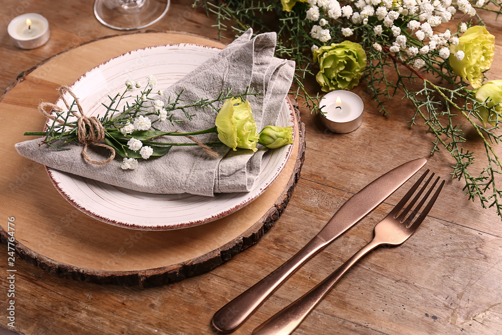 Beautiful festive table setting with floral decor on wooden background