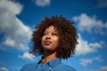 Wall Mural - Beautiful black woman wearing headphones in urban city setting during sunrise