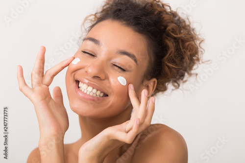 Fotografía Portrait of laughing woman applying face cream