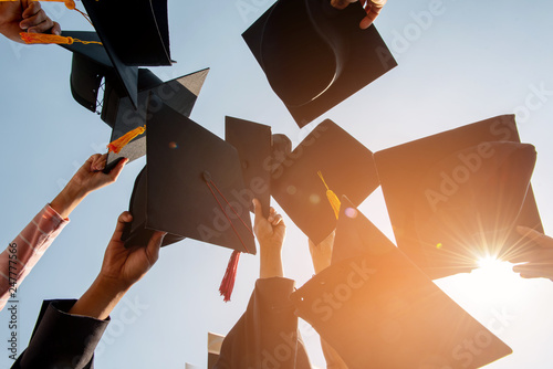 Fotomural Black hat of the graduates floating in the sky.