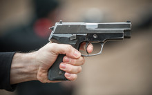 Left Hand Shooter Shooting And Holding Gun. Close-up Detail View