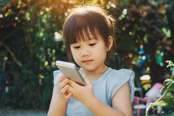 Wall Mural - Kids using smart phone : Some research says entertainment media (including TV) be avoided for infants and children under age 2 and cell phone radiation can harm your baby and may cause of ADHD.