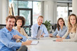 © nenadaksic - Small group of business people posing in office. Start up business concept. Multi ethnic group.