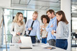 © nenadaksic - Small group of business people standing at office and solving problem at meeting. Multi cultural group.
