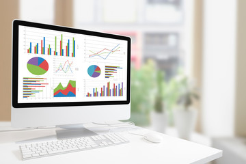Poster - Modern computer with keyboard and mouse on white table showing charts and graph on screen against  modern  indoor  green plants and window background , Analysis Business, Statistics Concept
