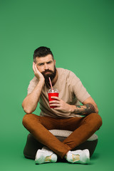 Wall Mural - handsome bored man holding soda on green