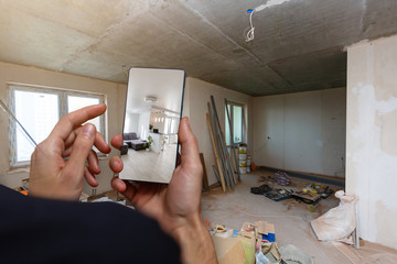 Mobile device with man hands taking picture in modern loft studio