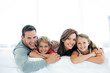 © potstock - happy family with two children lying down and looking at camera - portrait