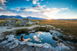 © Tandem Stock - A woman relaxes in Wild Willy's Hot Springs at sunset enjoying a stunning view of the Sierra Nevada mountains near Mammoth Lakes, California.