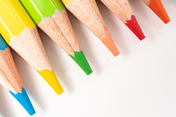 Wall Mural - Colored pencils in a row isolated on white background.