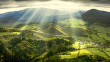 Landscape And Nature In The Spring. Landscape With Dramatic Sky And Green Meadows. The Sun Rays Through The Clouds.