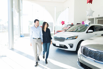 Man And Woman Deciding Which Car To Buy