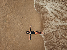 Aerial Top View Young Woman Lying On The Sand Beach And Waves