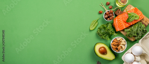 Fotografía Keto diet concept - salmon, avocado, eggs, nuts and seeds, bright green backgrou