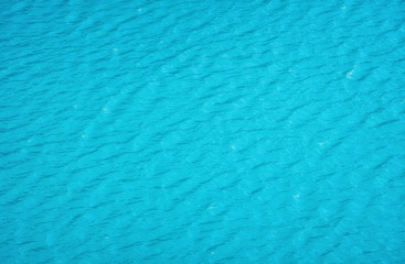 Wall Mural - aerial view at the water surface. turquoise sea as a background. waves on the sea. waves as a backgr