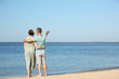 © New Africa - Happy mature couple at beach on sunny day
