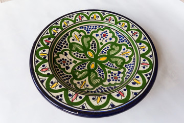 a white round plate with floral and line pattern on white background