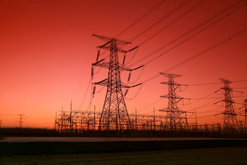 high voltage electric power steel tower in the setting sun