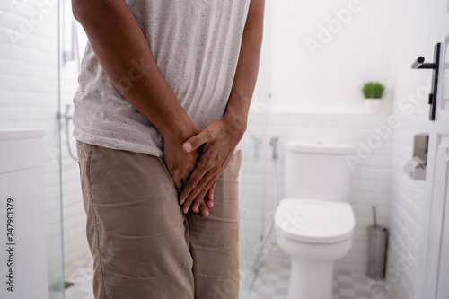 Fotomural gesture of man hold his genitals in the toilet