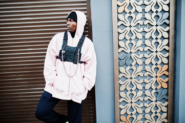 Wall Mural - Stylish urban style african american man in pink hoodie posed. Afro rapper guy.