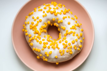 Tasty white donut with yellow round sprinkles. Background, texture. Close up. Macro