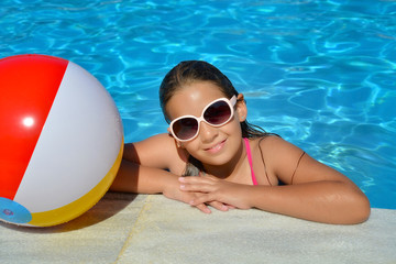 Real adorable girl relaxing in swimming pool