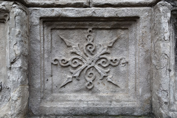 Close-up: stone element of an old ornament on the collapsing wall of an ancient temple 2