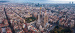 Aerial; drone view of main Gaudi project Sagrada Familia Temple; majestic building towering over the rooftops of Eixample district; one of the famous attraction for tourists and travelers in Barcelona