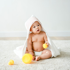 Wall Mural - Baby in a bath towel with rubber ducks