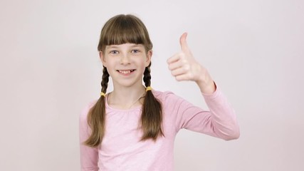 conceptual emotions teenager girl showing thumbs up , portrait on a light background