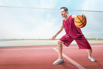 Poster - Cheerful asian basketball player man in action with the ball