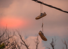 A Pair Of Sneakers Hanging From An Overhead Power Line Isolated Against The Skyline Image With Copy Space