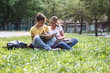 © BalanceFormCreative - Two young students sitting at the campus yard , reading book and preparing for university exam.