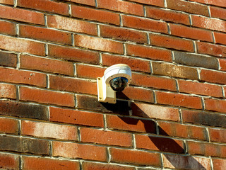 surveillance camera mounted on a brick wall