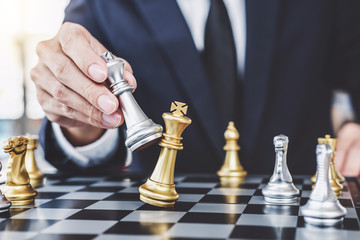 Wall Mural - Businessman playing chess game reaching to plan strategy for success, thinking for planning overcoming difficulty and achieving goals business strategy for win, management or leadership concept