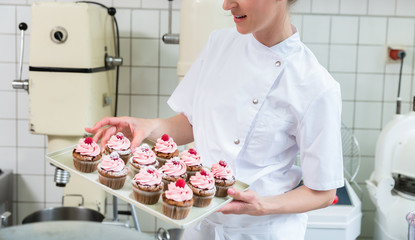 Baker women in pastry bakery working on muffins