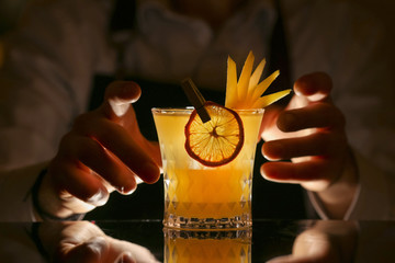 Wall Mural - Fresh alcohol Penicillin cocktail with orange slice and ice cubes. Barmen making alcohol cocktail	