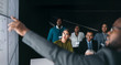 © JonoErasmus - Black african businessman giving a presentation at a business conference. Large video screen with charts and graphs next to him