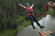 Young woman jumps on a rope from a great height. Ropejumping.