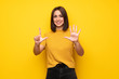 © luismolinero - Young woman over yellow wall counting seven with fingers