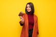 © luismolinero - Young woman with coat holding a wallet