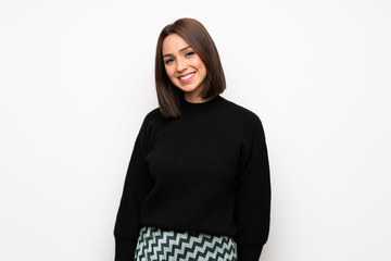 Young woman over white wall laughing looking to the front