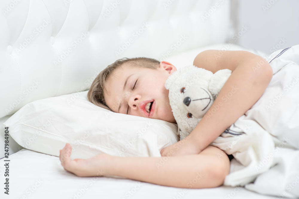 young-boy-with-toy-bear-is-sleeping-with-his-mouth-open-snoring-stock