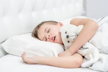 Poster - Young boy with toy bear is sleeping with his mouth open, snoring