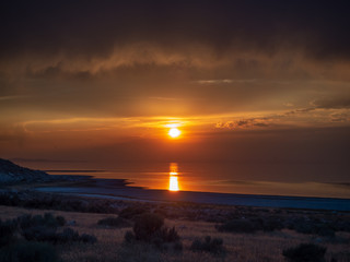 Sunset on the Antelope Island on the great Salt Lake outside the City, colorful orange dusk above a road with buffalos panorama background