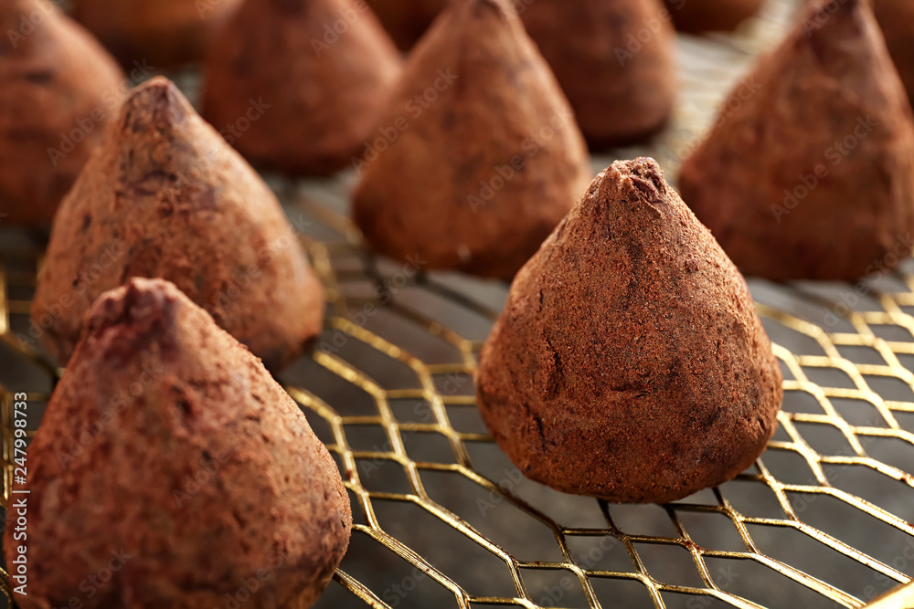 Tasty sweet truffles on rack, closeup