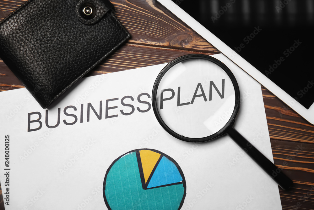 Sheet of paper with chart, tablet PC and wallet on wooden table. Concept of business planning