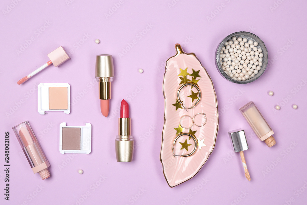 Set of makeup cosmetics with jewelry on color background